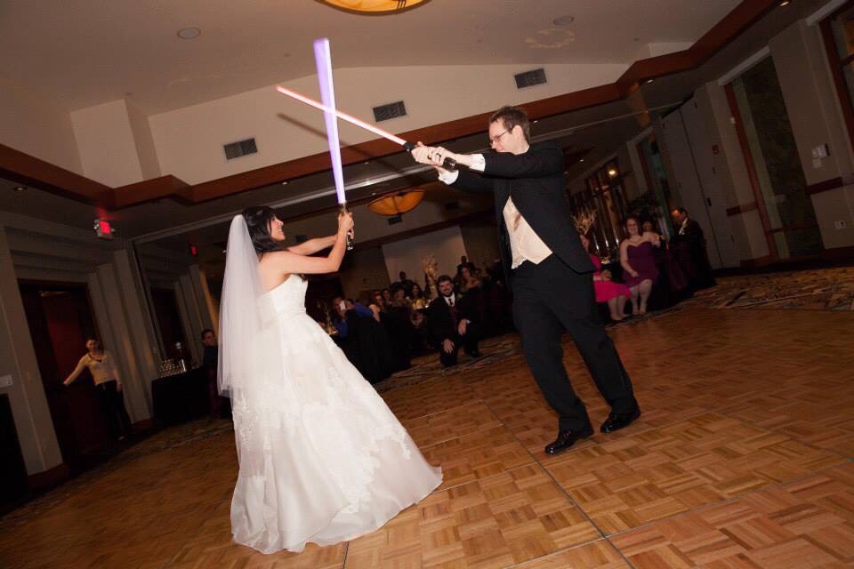 A bride and groom enter into a lightsaber battle at their Star Wars wedding