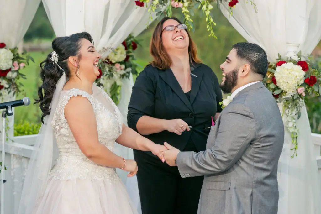 Inland Empire wedding officiant Let's Get Married by Marie laughs with the bride and groom during their wedding ceremony