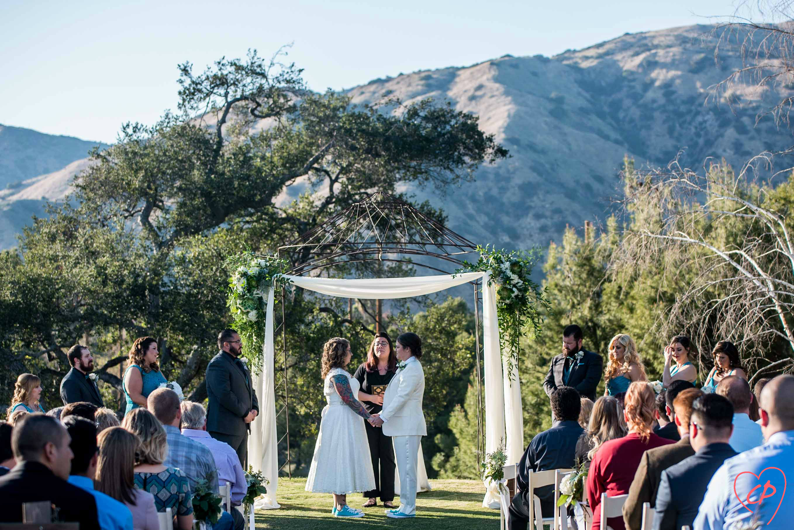 Los Angeles LGBTQ wedding performed by Let's Get Married by Marie at Wedgewood La Verne with alternative lesbian wedding style, tea length wedding dress, wedding day Converse, and a white wedding suit