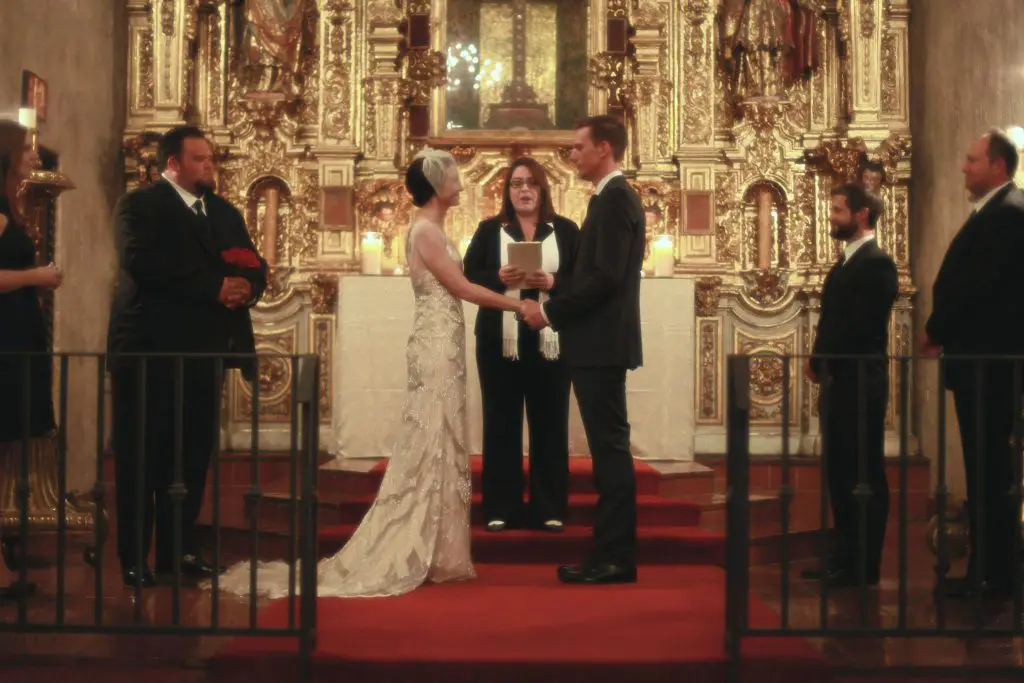 Inland Empire wedding officiant Minister Marie of Let's Get Married by Marie leads a wedding ceremony for a bride in a Gatsby-style wedding dress and her groom in the St. Francis chapel at Mission Inn in downtown Riverside