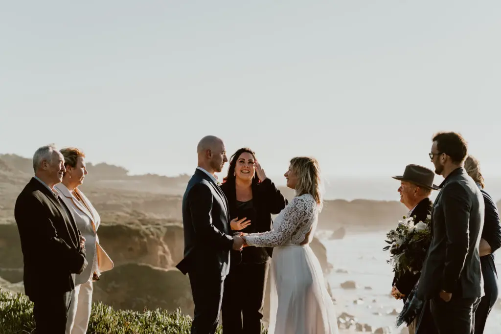 A couple elopes during their Big Sur elopement package with Let's Get Married by Marie on the cliffs of Big Sur overlooking the ocean