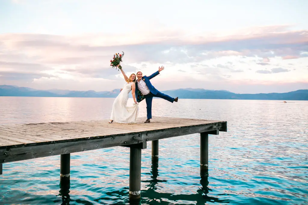 A newlywed couple goof off on a pier at Lake Tahoe during their Choose Your Own Adventure Elopement Package with Let's Get Married by Marie