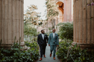 San Francisco wedding officiant Let's Get Married by Marie features Black gay husbands holding hands at the San Francisco Palace of the Fine Arts after their wedding ceremony