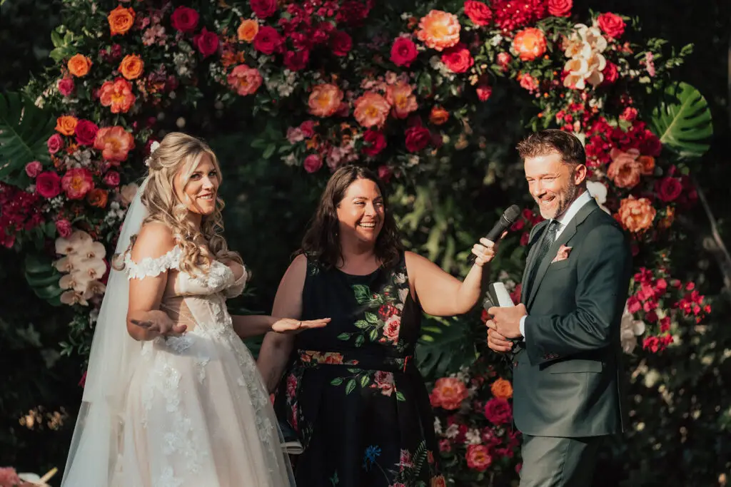 The Parker Palm Springs wedding officiant Let's Get Married by Marie smiles and laughs with bride Ashley and groom Chris during their vows