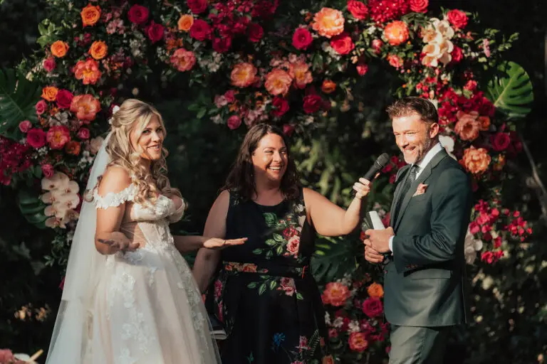 The Parker Palm Springs wedding officiant Let's Get Married by Marie smiles and laughs with bride Ashley and groom Chris during their vows