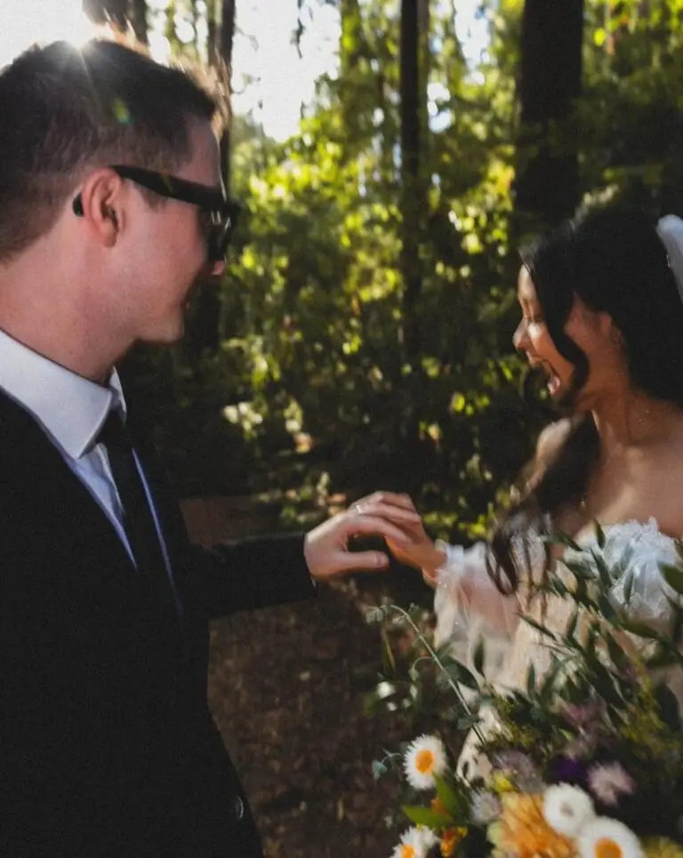 a bride laughs looking at her groom's new wedding band during their Redwoods elopement with Let's Get Married by Marie
